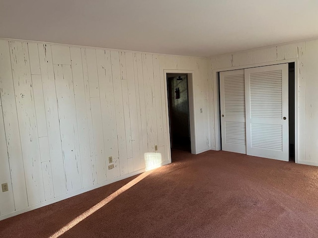 unfurnished bedroom with carpet and wooden walls