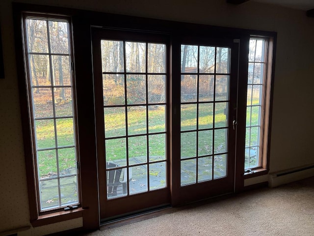 doorway to outside with a baseboard heating unit and carpet flooring