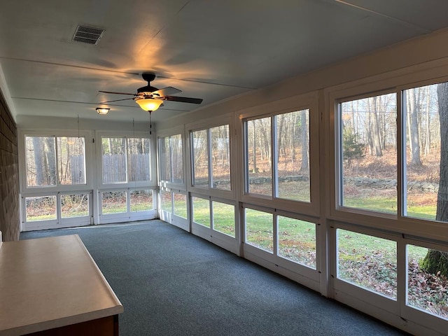 unfurnished sunroom with ceiling fan and a healthy amount of sunlight