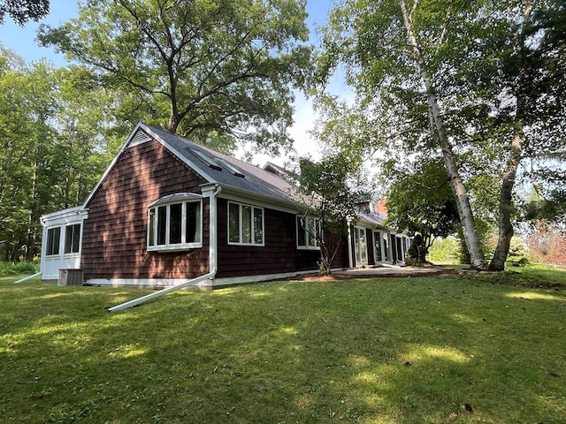 rear view of property featuring a lawn