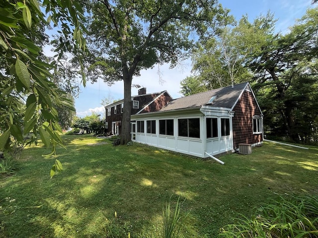 view of side of home featuring central AC and a lawn