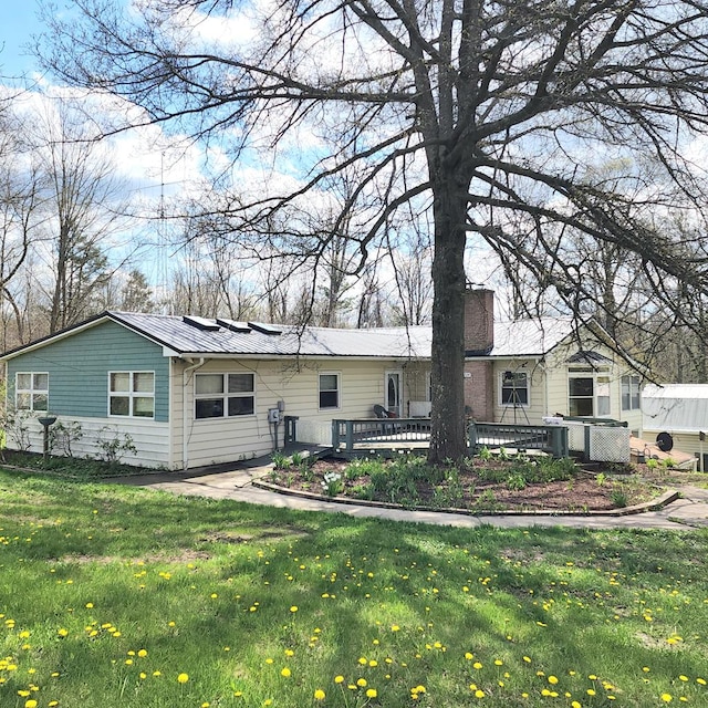 back of house featuring a deck and a yard