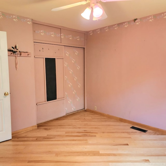 unfurnished room with ceiling fan and wood-type flooring