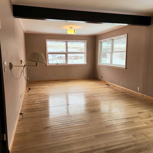 unfurnished room featuring light hardwood / wood-style floors and crown molding