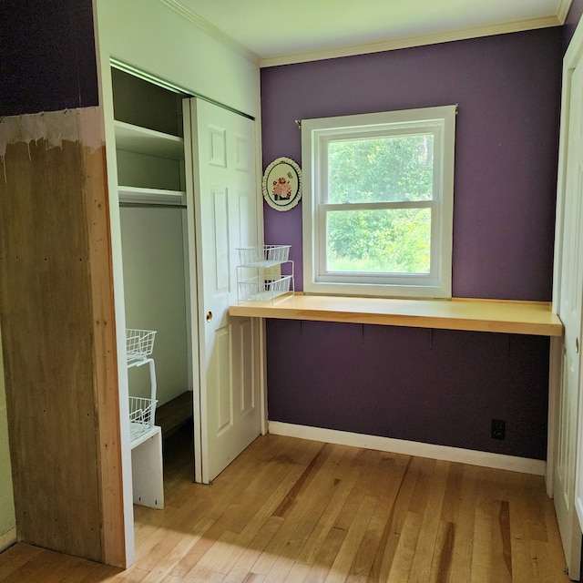 interior space with light hardwood / wood-style flooring, a closet, and ornamental molding