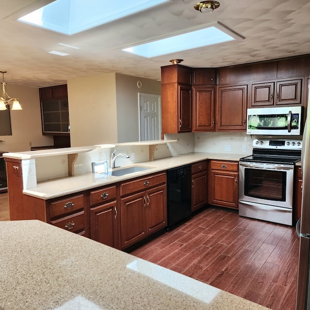 kitchen with kitchen peninsula, a skylight, stainless steel appliances, dark wood-type flooring, and sink