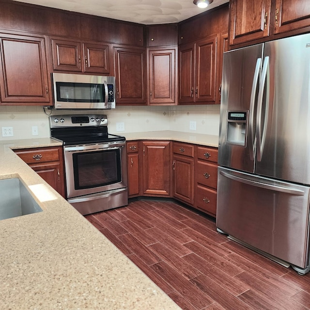 kitchen featuring decorative backsplash, dark hardwood / wood-style flooring, and stainless steel appliances