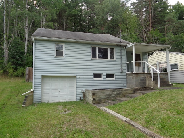 back of property featuring a garage and a yard