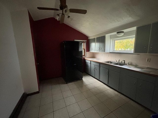 kitchen with gray cabinets, lofted ceiling, black refrigerator, and a textured ceiling