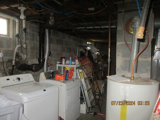 clothes washing area featuring water heater, sink, and washer and dryer