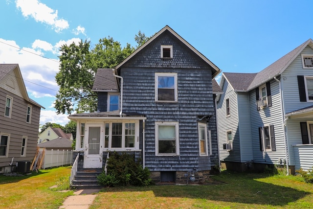 view of front of property with central AC unit and a front yard