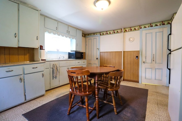 dining space featuring wood walls