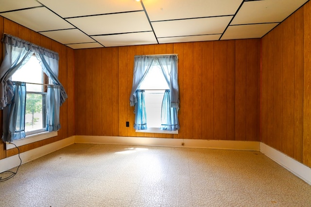 empty room with wooden walls and a healthy amount of sunlight