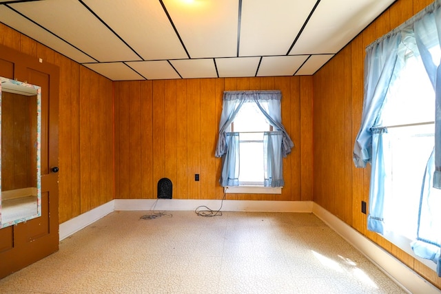 unfurnished room featuring wood walls