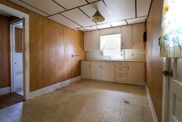 kitchen with cream cabinets and wood walls