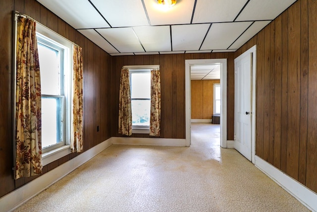 empty room featuring radiator heating unit and wooden walls