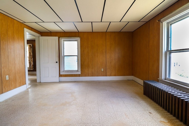 empty room with wood walls and radiator heating unit