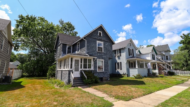 view of front facade featuring central AC unit and a front yard