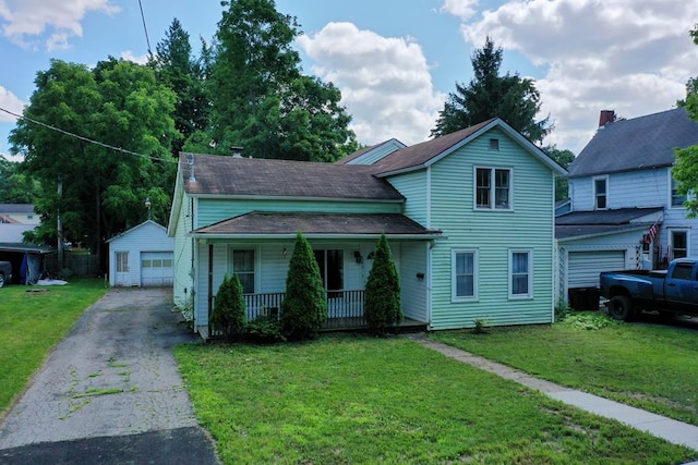 view of front of house with an outbuilding, a porch, a garage, and a front lawn