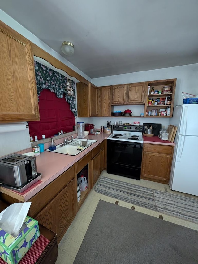 kitchen with white refrigerator, range with electric stovetop, and sink