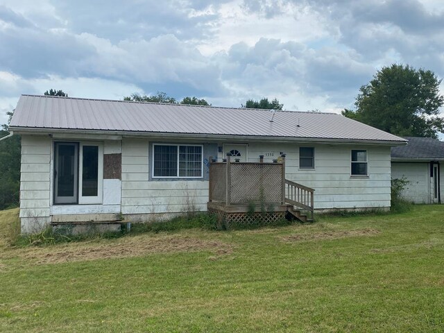 rear view of property featuring a yard