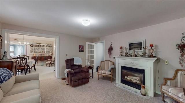 carpeted living room featuring a notable chandelier