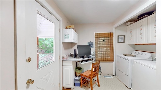 laundry area featuring separate washer and dryer and cabinets