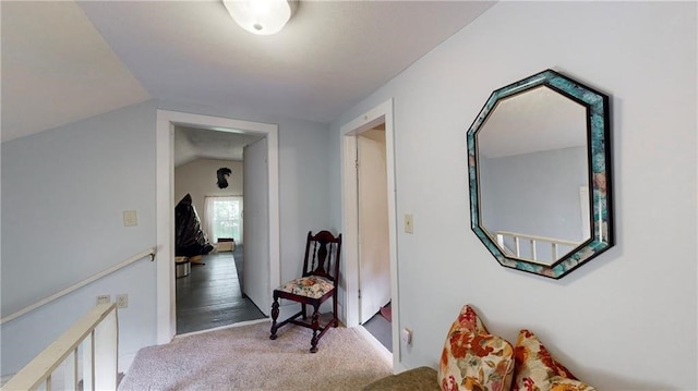 hall with vaulted ceiling and light colored carpet