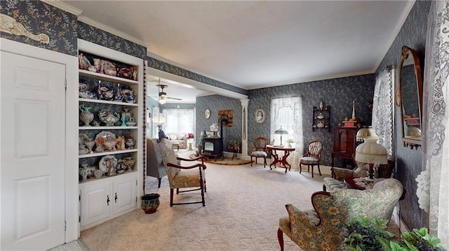 living area with crown molding, ceiling fan, and carpet floors