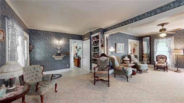 living area with crown molding, carpet flooring, and ceiling fan