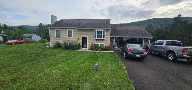 view of front facade featuring a mountain view and a front yard