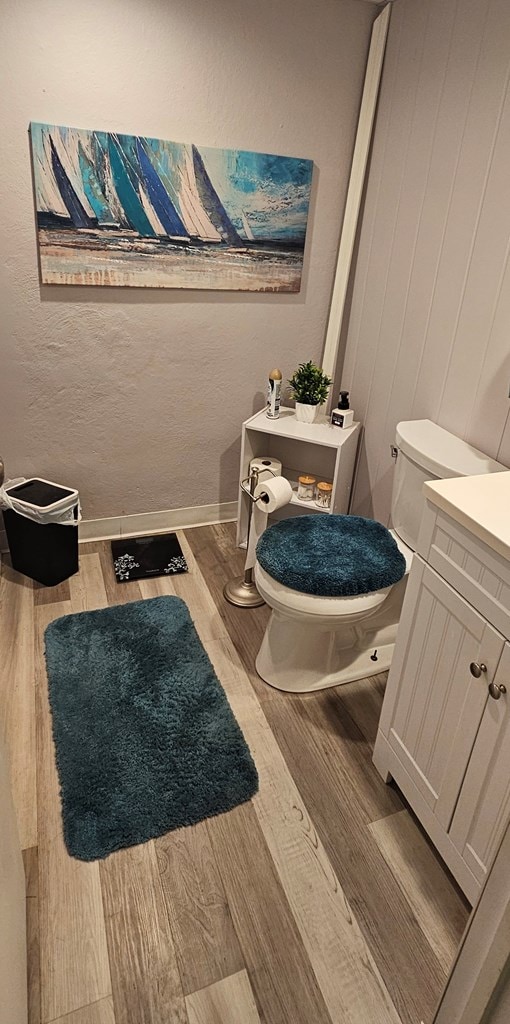 bathroom featuring wood-type flooring, vanity, and toilet