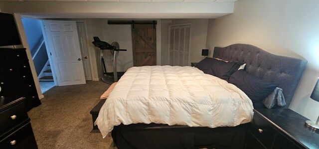 bedroom featuring a barn door and carpet floors