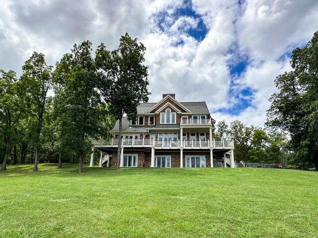 rear view of house featuring a yard