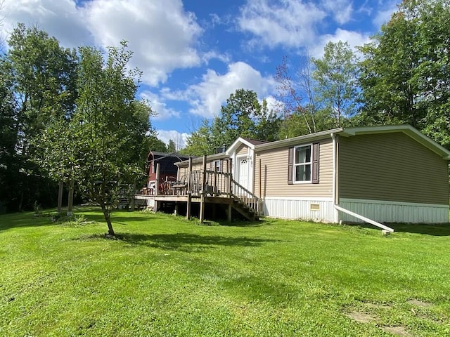 back of property with a wooden deck and a yard