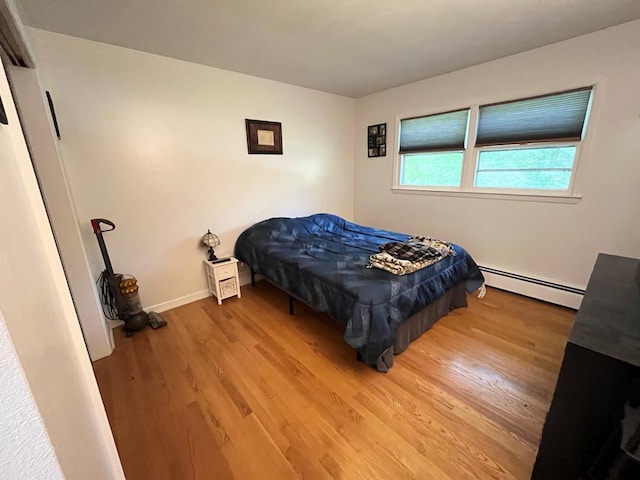 bedroom featuring a baseboard radiator and hardwood / wood-style floors