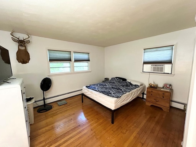 bedroom featuring cooling unit, a baseboard radiator, and hardwood / wood-style floors