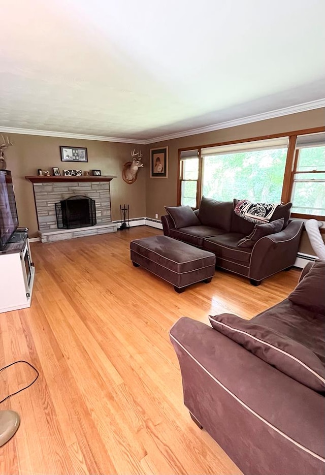 living room with ornamental molding, plenty of natural light, a fireplace, and light hardwood / wood-style floors