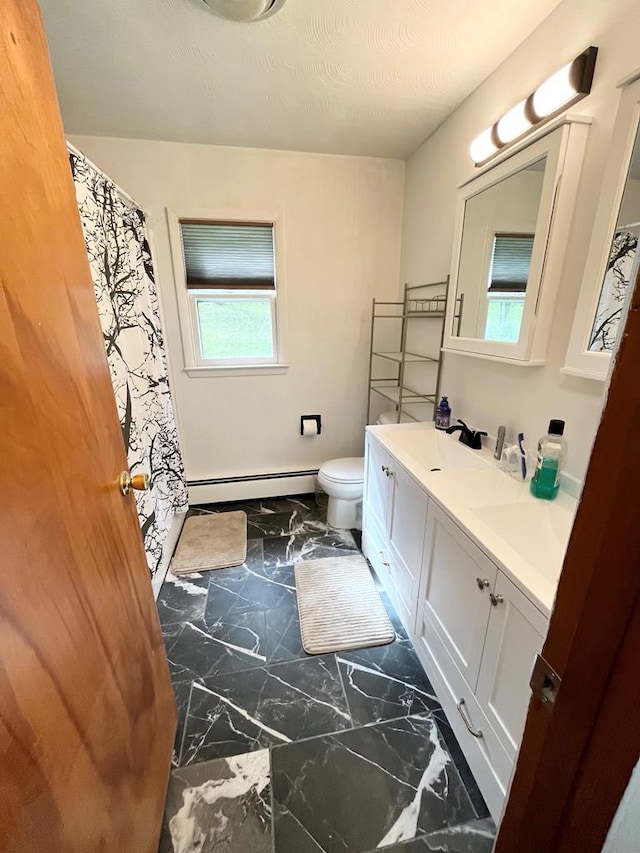 bathroom featuring baseboard heating, vanity, and toilet