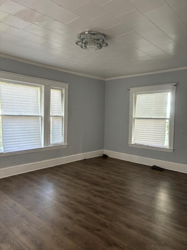 spare room featuring crown molding and dark hardwood / wood-style flooring