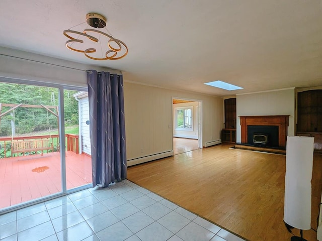 unfurnished living room featuring a baseboard radiator, ornamental molding, light hardwood / wood-style flooring, and a skylight