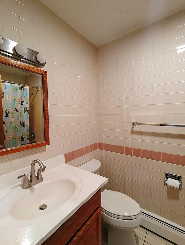 bathroom with a baseboard radiator, tile walls, vanity, toilet, and tile patterned floors