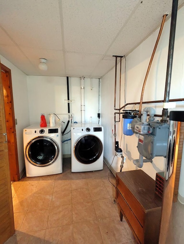 washroom with light tile patterned floors and washer and dryer