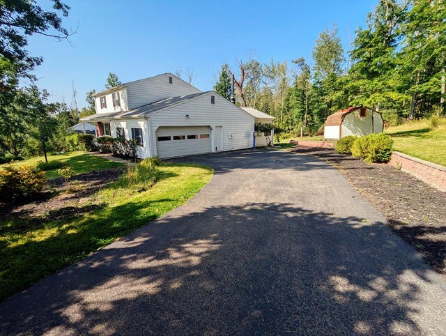 view of property exterior featuring a garage, a yard, and a shed