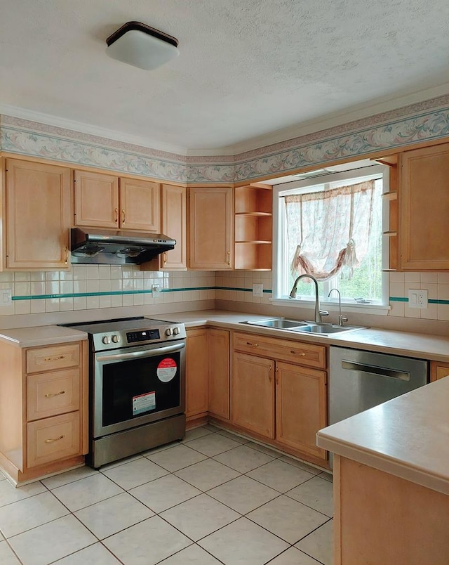 kitchen with light brown cabinetry, sink, decorative backsplash, stainless steel appliances, and a textured ceiling