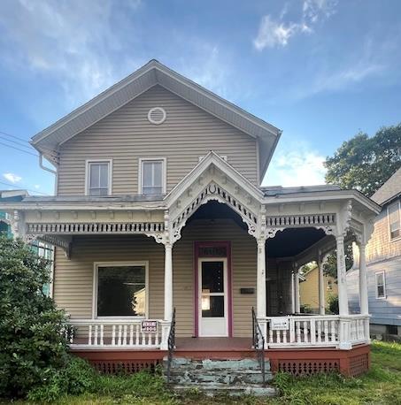 back of property featuring covered porch