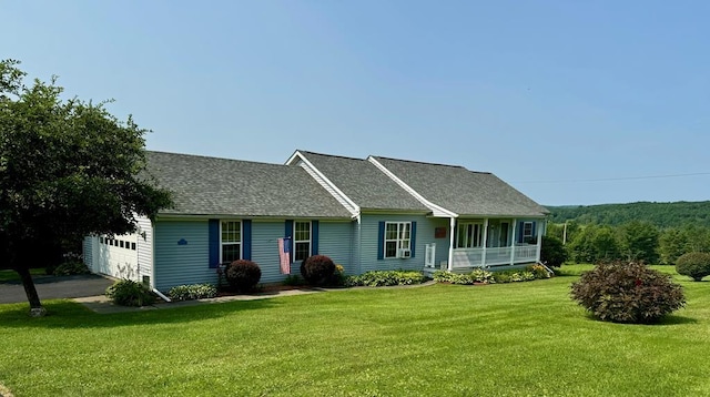 single story home featuring covered porch, a garage, and a front lawn