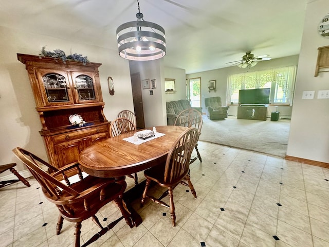 dining area featuring ceiling fan with notable chandelier and light colored carpet