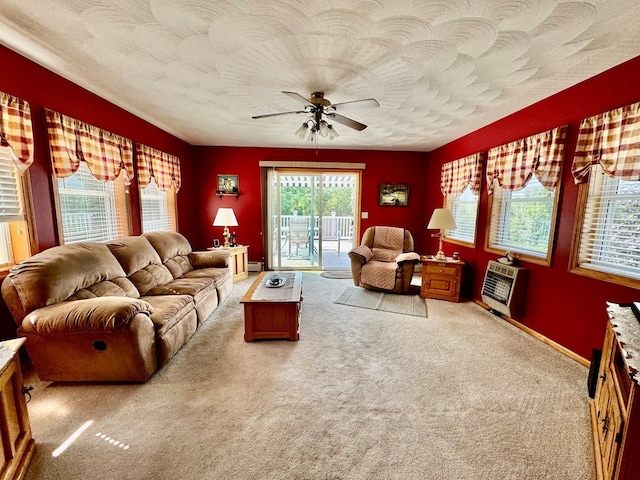 carpeted living room with heating unit and ceiling fan