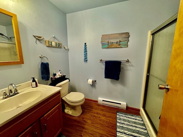 bathroom with walk in shower, a baseboard heating unit, hardwood / wood-style floors, toilet, and vanity